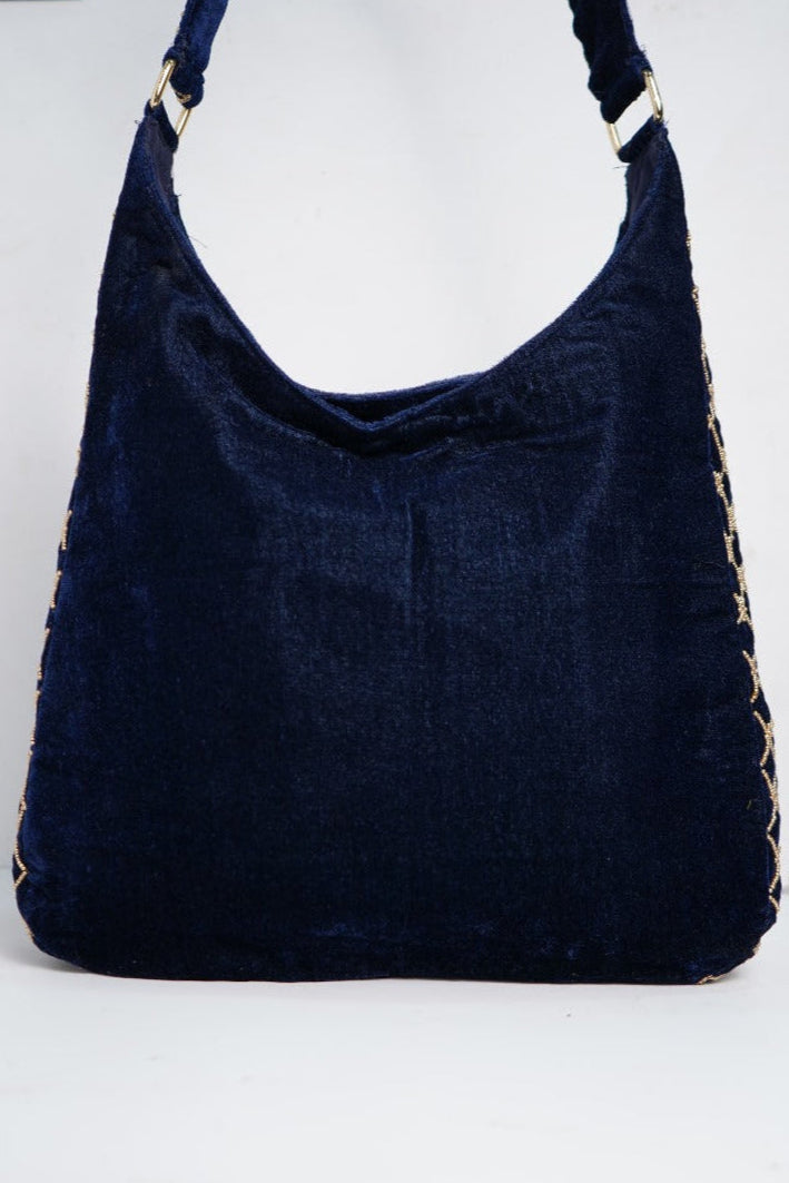 Navy blue handbag with decorative straps on a white background