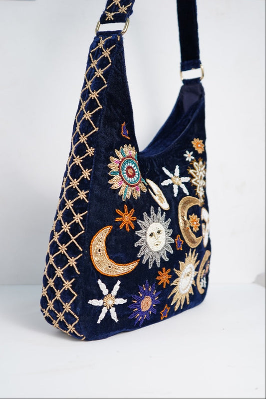 Navy blue handbag with celestial embroidery on a white background